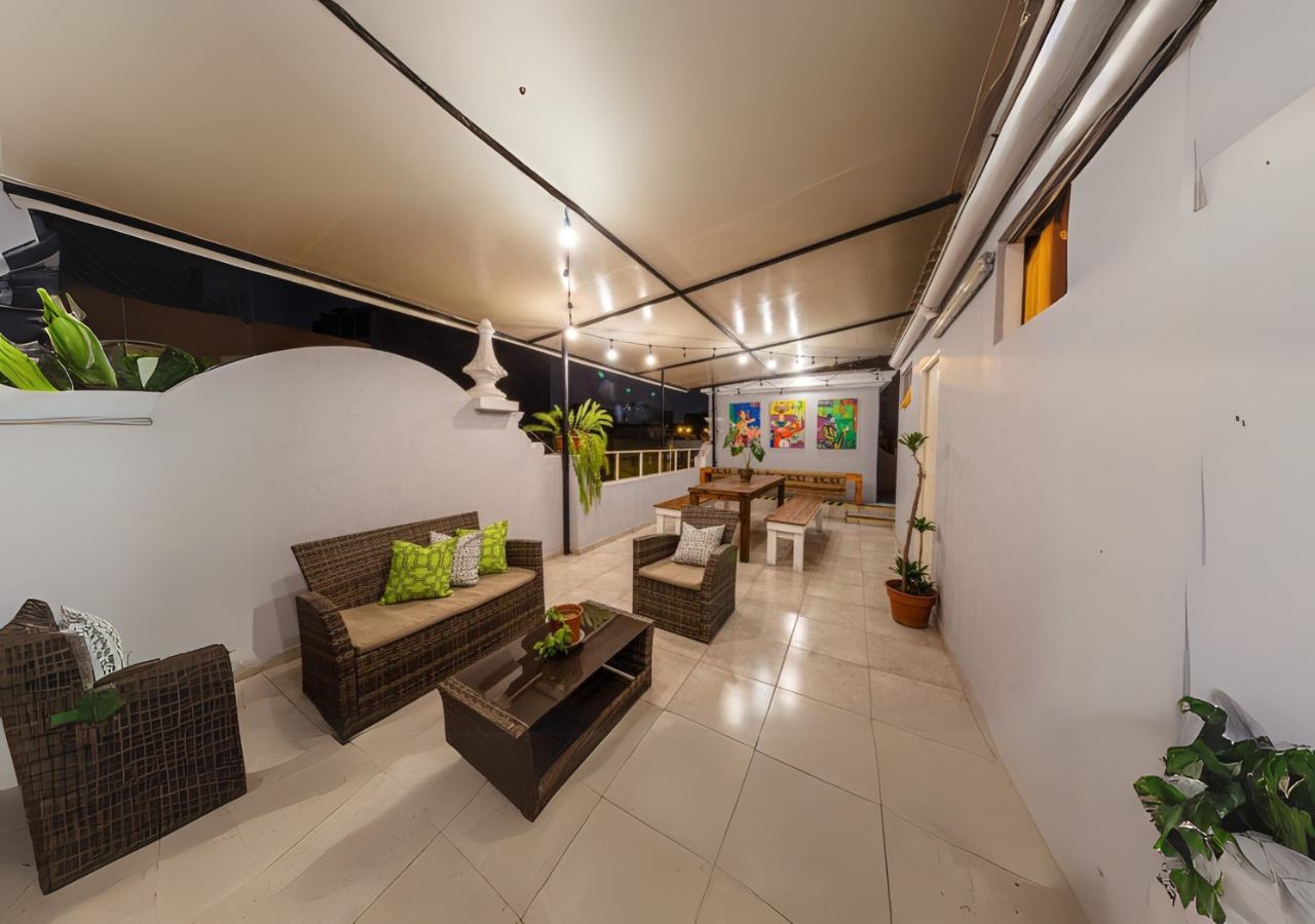 Terraza de Casa Águila y Cóndor de noche, con guirnaldas de luces, sillones y cuadros de colores