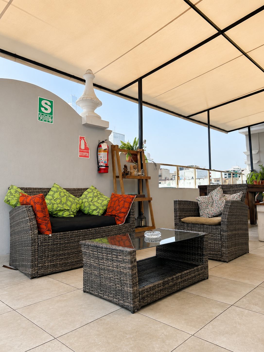 Sillones de la terraza con cojines verdes y naranjas